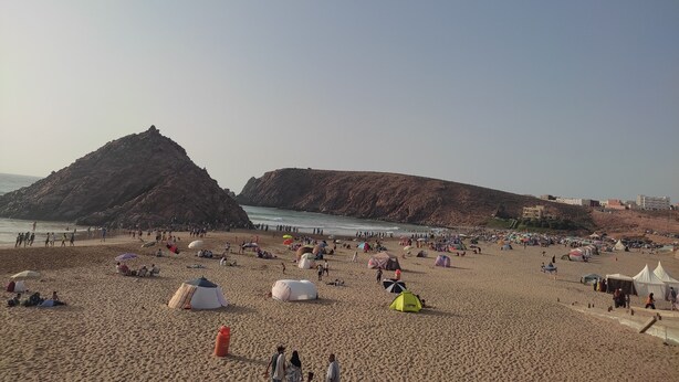 A beach with tents and people.