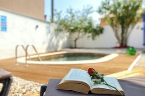 An open book with a rose on a wooden surface, a pool, and a white wall with a blue sign in the background. - House 2227/68186 (Istria - Loborika), 11000m from the beach (Loborika)