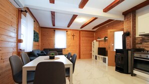 A wooden interior with a dining table, chairs, a sofa, a TV, and a fireplace. - House 2233/68573 (Istria - Vodnjan), 10000m from the beach (Vodnjan)