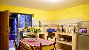 Una cucina con tavolo da pranzo, sedie, frigorifero e piano cottura.