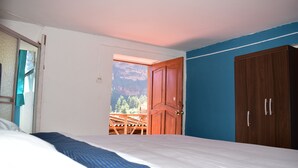 Una camera da letto con un letto, un armadio in legno e una porta che dà su un balcone esterno.