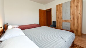 Un dormitorio con dos camas, un armario y una silla.
