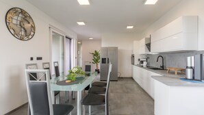 A modern kitchen with white cabinets, a glass dining table, and a stainless steel refrigerator. - House 2258/73634 (Istria - Valbandon), 1500m from the beach (Valbandon)