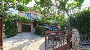 A residential property with a gated entrance, a paved driveway, and a building with a dark-colored garage door. - Apartment 2276/75855 (Istria - Pula), 3500m from the beach (Pula)