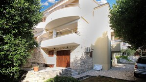 A two-story building with a stone facade, a balcony, and a car parked in front. - Apartment 2277/75908 (Istria - Premantura), 300m from the beach (Premantura)