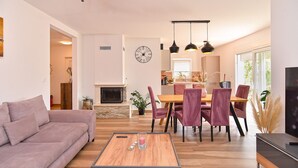 A modern living room with a sofa, coffee table, and dining area with chairs. - House 2279/75934 (Istria - Medulin), 350m from the beach (Medulin)