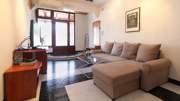 A living room with a sofa, a coffee table, and a desk with a computer. There is a door with glass panels and a window. - Apartment 2281/76013 (Istria - Pula), 2500m from the beach (Pula)