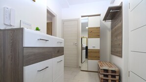 Une petite pièce comprenant une armoire, un miroir et une palette en bois.