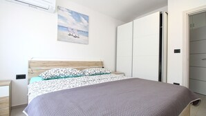 Une chambre à coucher avec un lit, une table de chevet, une armoire et un tableau au mur.