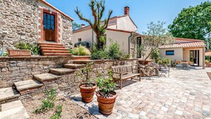 A stone building with a red door, a wooden bench, and potted plants. - Maison Zenith - Five Bedroom Villa, Sleeps 10 (Beaurepaire)