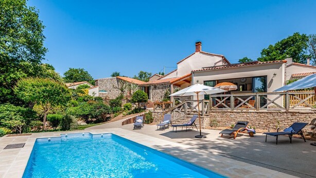A swimming pool with lounge chairs and umbrellas, surrounded by a stone wall and greenery. - Maison Zenith - Five Bedroom Villa, Sleeps 10 (Beaurepaire)