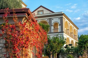 A building with a stone facade, arched windows, and a balcony. - Villa Lucrezia by Elite Villas (Piano di Sorrento)