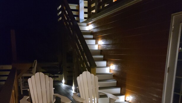 Een terras met houten stoelen en een trap.