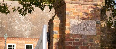 A brick wall with a plaque reading "TACATO FARM".