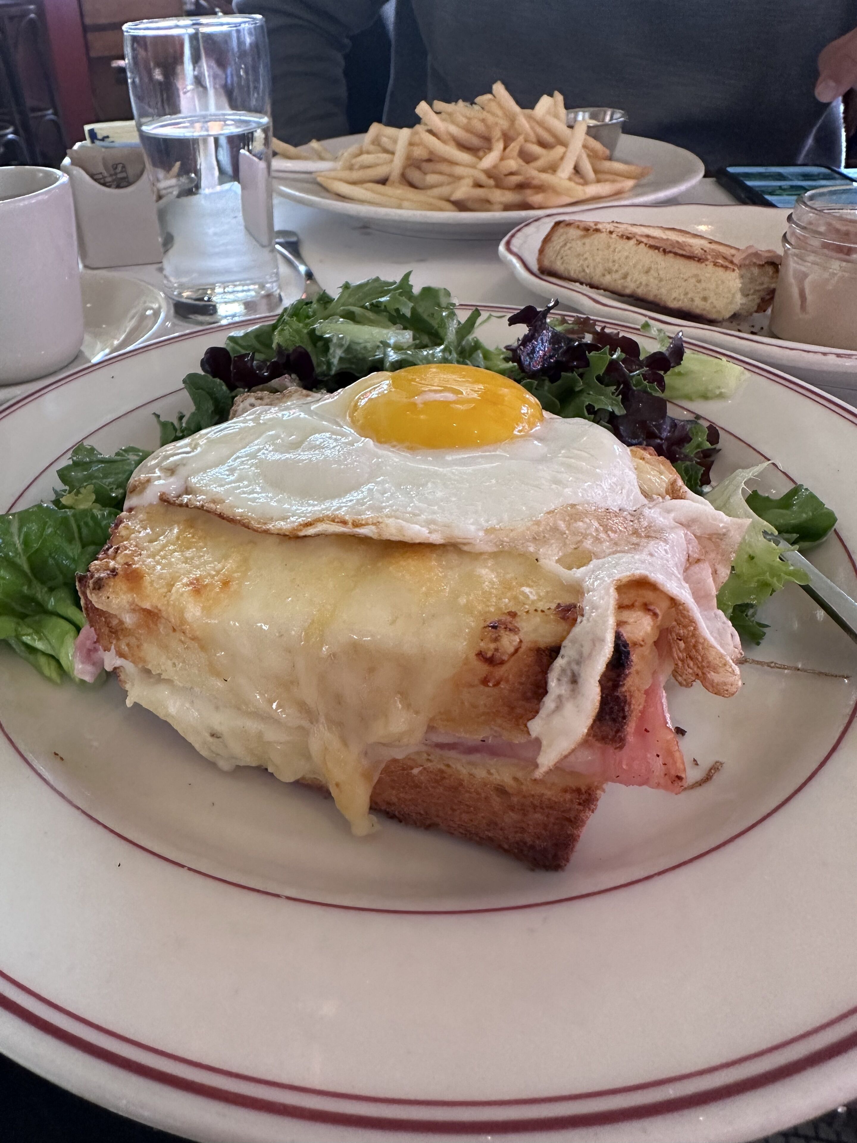 A plate with a sandwich, a fried egg, and fries.