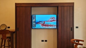 Een televisie bevestigd aan een houten kastje, waarop een landschapsafbeelding wordt getoond.