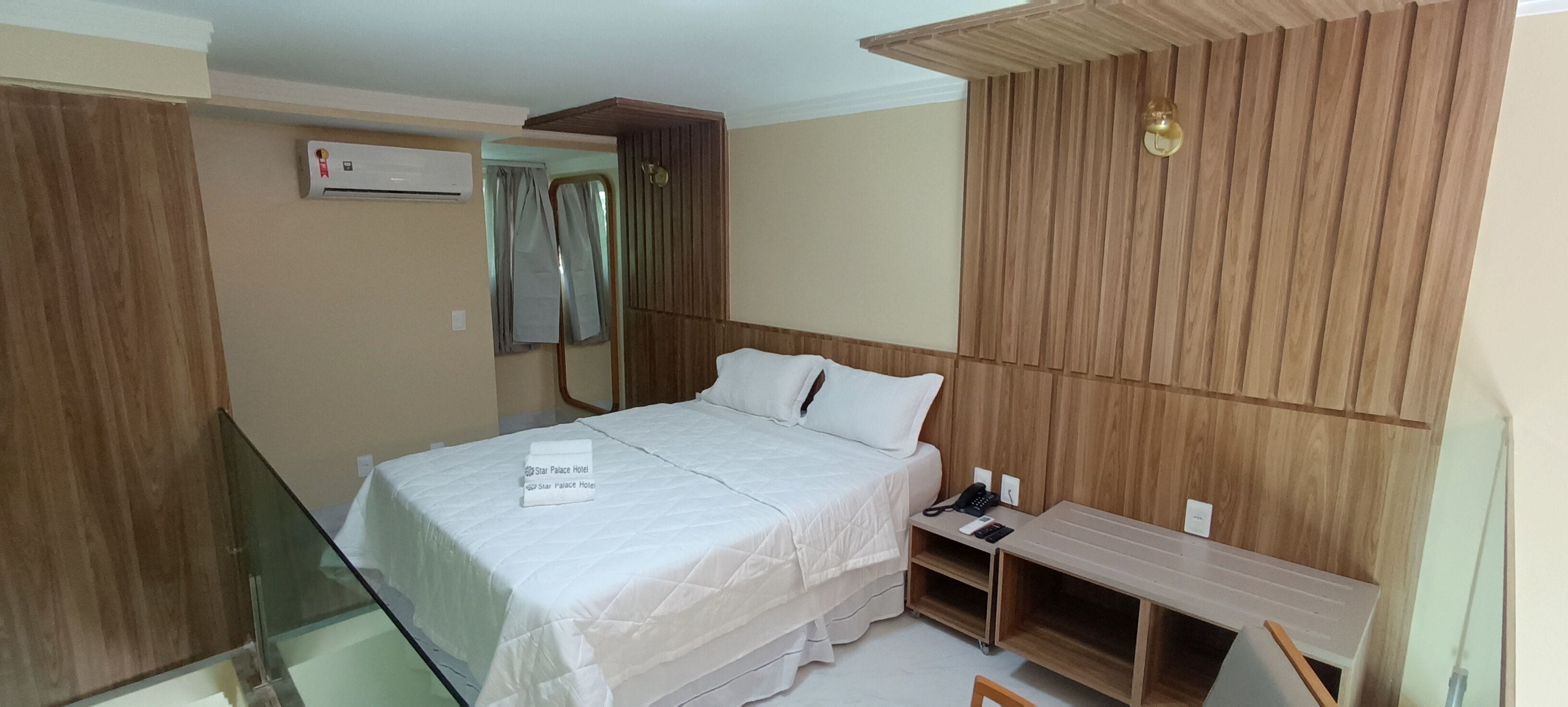 Une chambre d’hôtel avec un lit, une table de chevet et un petit bureau.