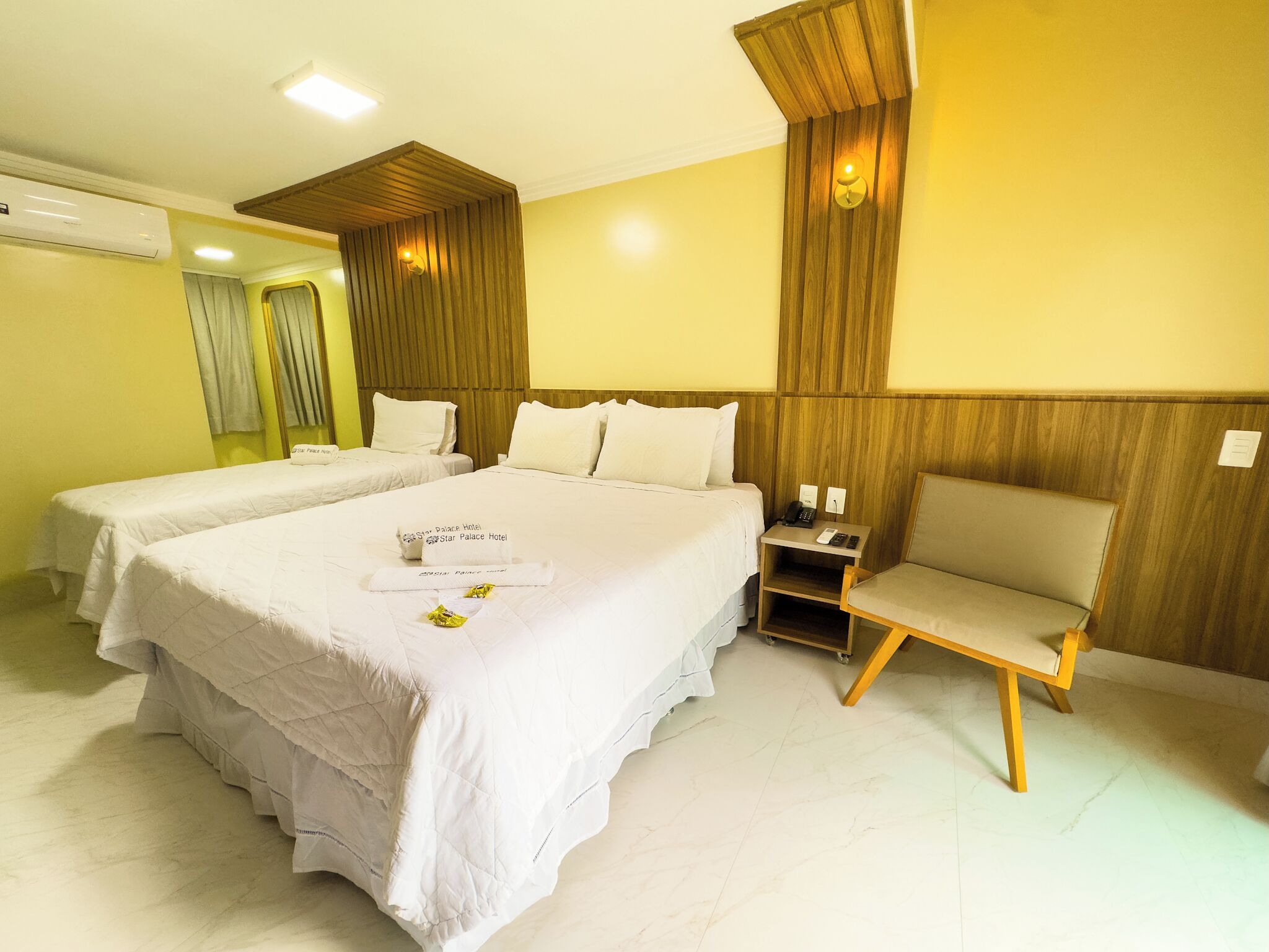 Habitación de hotel con dos camas, un escritorio y una silla.