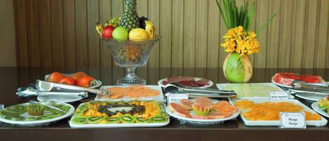 Een buffet met verschillende soorten fruit, groenten en vlees.