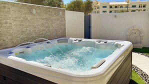 A hot tub with water jets, surrounded by a brick wall and a white wall with a stone archway. - B&B Albufeira City Room Junior with Private Bathroom (Albufeira)