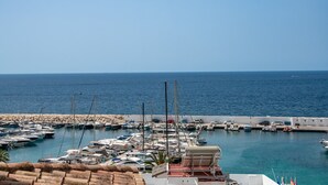 A marina with boats docked, a rocky shoreline, and a clear view of the sea. - Apartment Nautica Bay Moraira (Moraira)