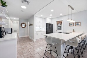 Enjoy cooking in this well-equipped kitchen with a central island, bar stools, and a coffee station.