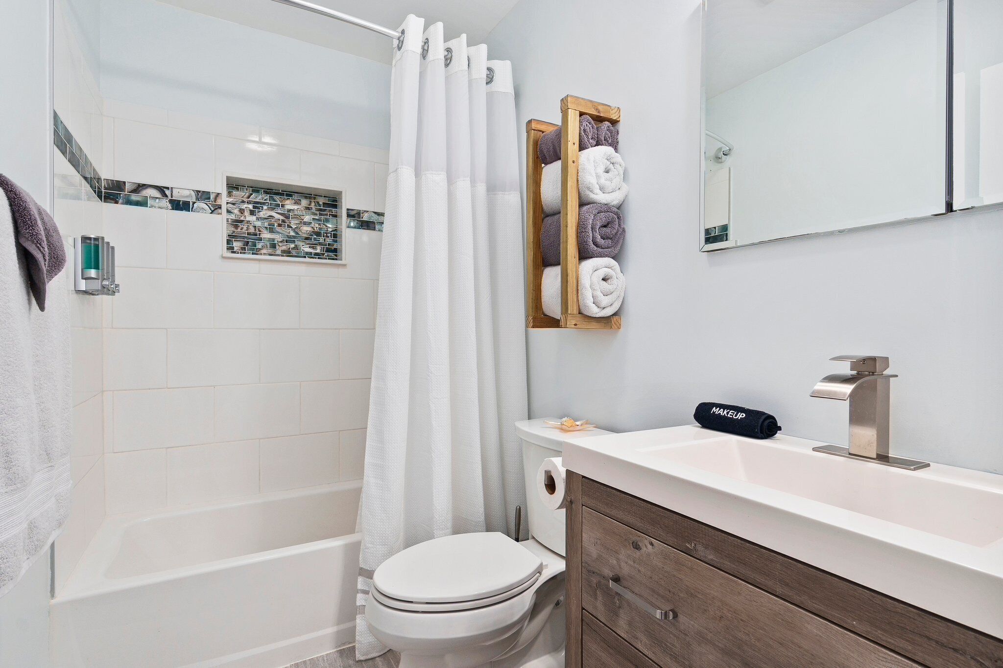 Une salle de bain moderne équipée d’une douche, de toilettes et d’un meuble-lavabo.