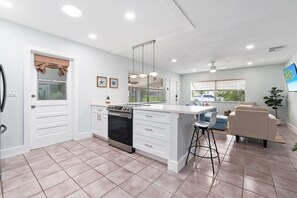 Enjoy cooking and dining in this well-equipped kitchen with a central island, stainless steel oven, and sink.