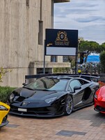 A black sports car parked in front of a building with a sign that reads 'Boutique Hotel SIRMIONE.'