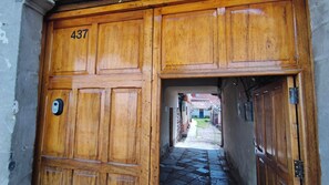 Una porta in legno con il numero 437 che dà su un stretto corridoio lastricato di pietra.