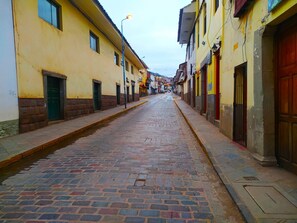 A cobblestone street lined with buildings, some with visible doors and windows. - Ekeko's Apartment - Calle Matara (Cusco)