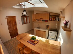 Una cucina con mobili in legno, forno a incasso e un lucernario.