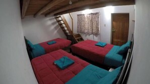 A dormitory room with two beds, wooden beams on the ceiling, a staircase, and a door. - Ekeko's Apartment - Calle Matara (Cusco)
