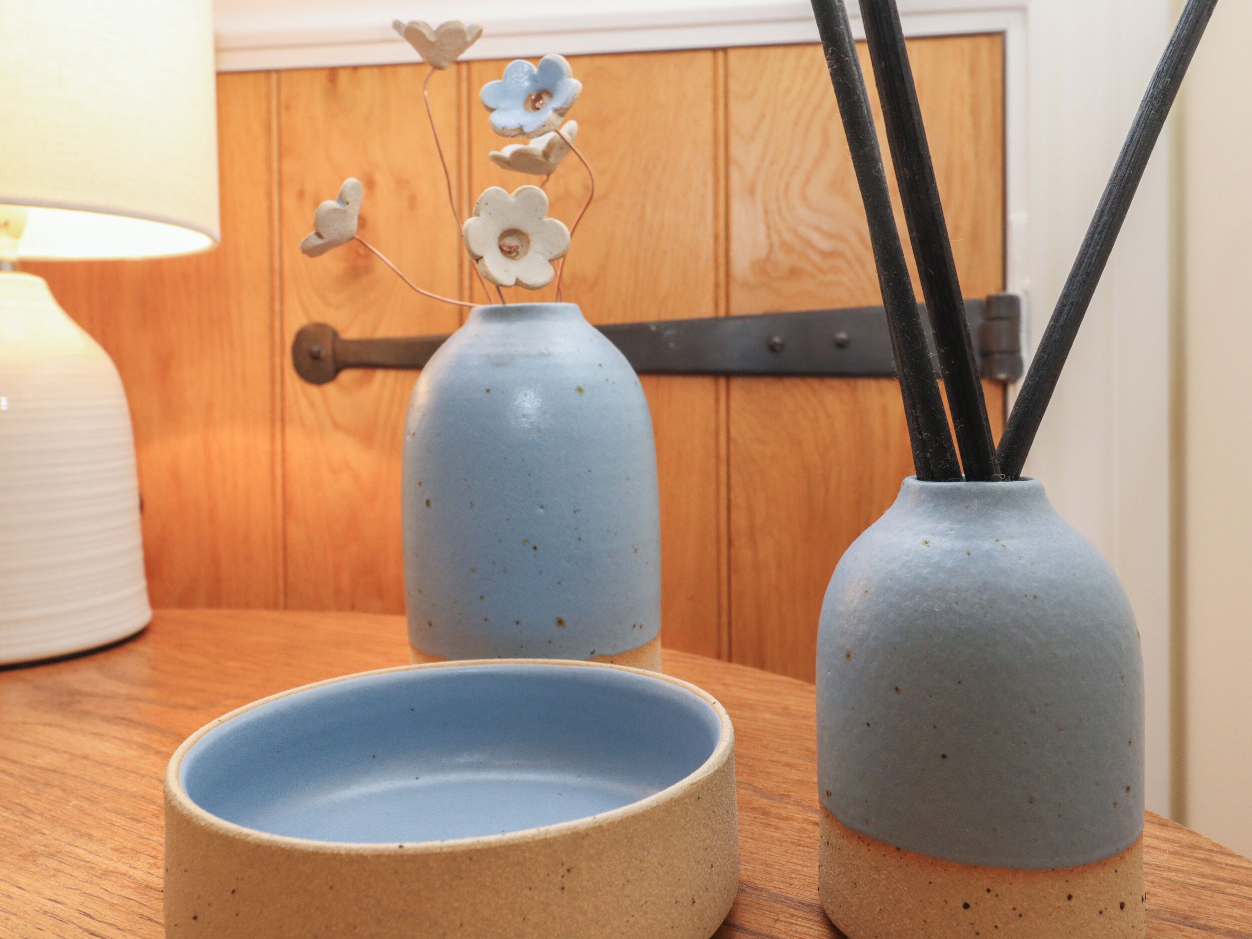 Uma mesa de madeira com dois vasos de cerâmica e uma tigela.