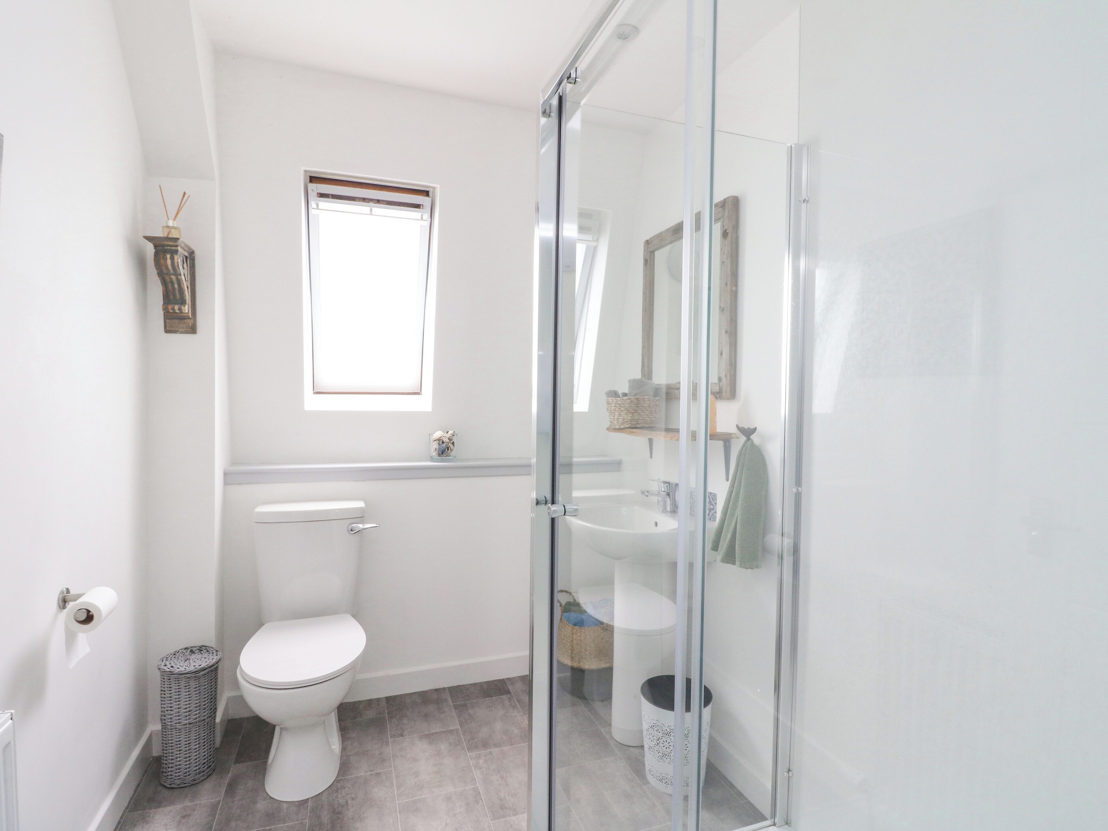 Un baño moderno con inodoro, lavabo y ducha.