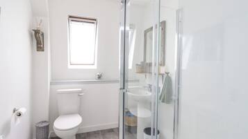 Un baño moderno con inodoro, lavabo y ducha.