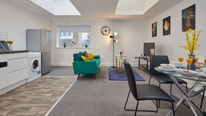 A modern apartment with a kitchen, dining area, and living space. It features skylights, a dining table with chairs, a sofa, and a small side table. - Sleeps 3: Family & Work Stays - FREE Parking & WiFi (Woodhouse)