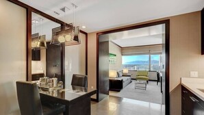 Una habitación de hotel moderna con comedor, sofá y vista a la ciudad.