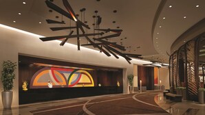 Un vestíbulo moderno con una recepción, arte abstracto y una zona de estar con asientos curvos.