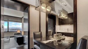 Une chambre d’hôtel moderne avec une grande table à manger, un canapé et une vue sur la ville.