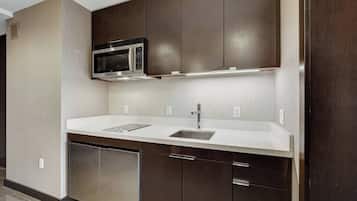 Een mini-koelkast, een magnetron, kookgerei, borden en bestek