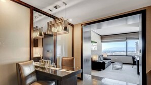 Une chambre d’hôtel moderne avec un coin repas, un canapé et une vue sur la ville.