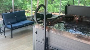 Un espace bien-être comprenant un jacuzzi, un banc et un canapé.