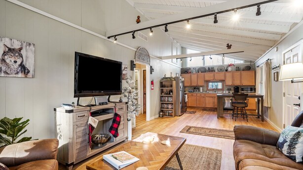 A spacious living room with a fireplace, a television, and a cozy seating area. - Woodland Cottage | Secluded Hocking Hills Getaway (Laurelville)