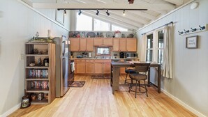 A kitchen with wooden cabinets, a central island, and a dining area with chairs.