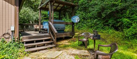A wooden cabin with a covered porch, a satellite dish, and outdoor seating.