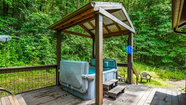 A wooden deck with a barbecue grill and a covered seating area. - Outback Cabin | Hocking Hills, Cozy Cabin for 2 (Laurelville)