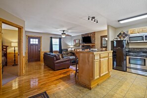 Ein geräumiges Wohnzimmer mit Kamin, eine Küche mit modernen Geräten und ein Essbereich.
