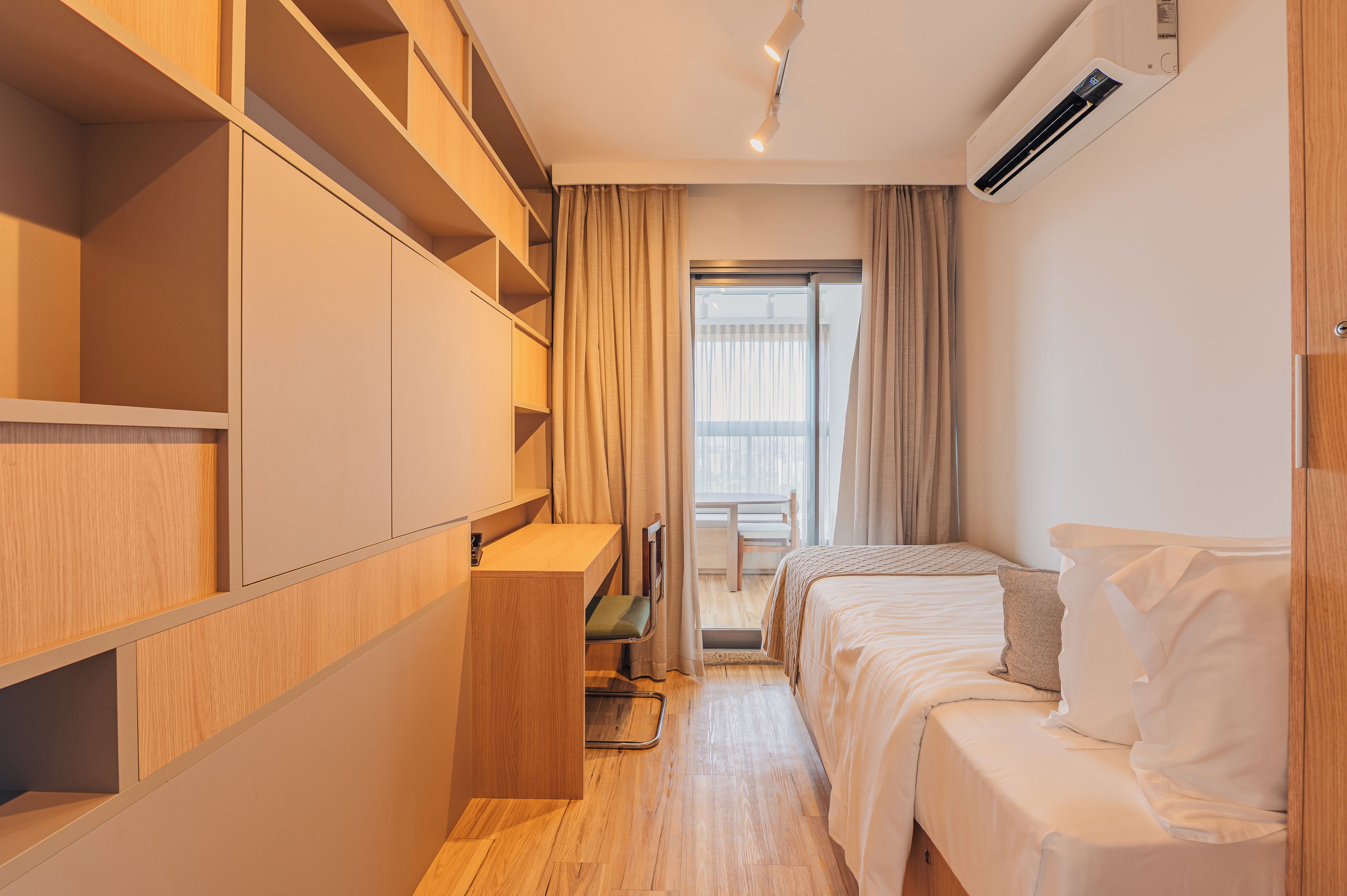 Una habitación de hotel con una cama, un escritorio y un armario.