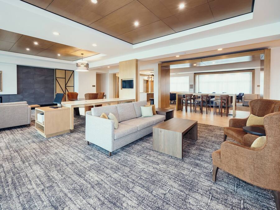 Un amplio salón con sofá, sillones, una mesa de centro y una mesa de comedor.